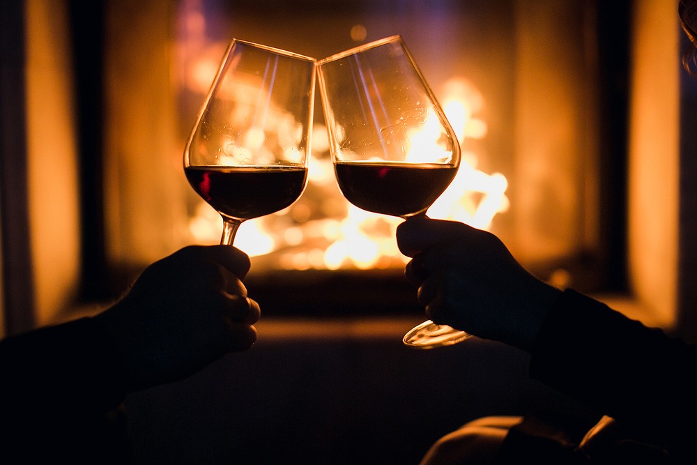 暖炉を背景にワインで乾杯している