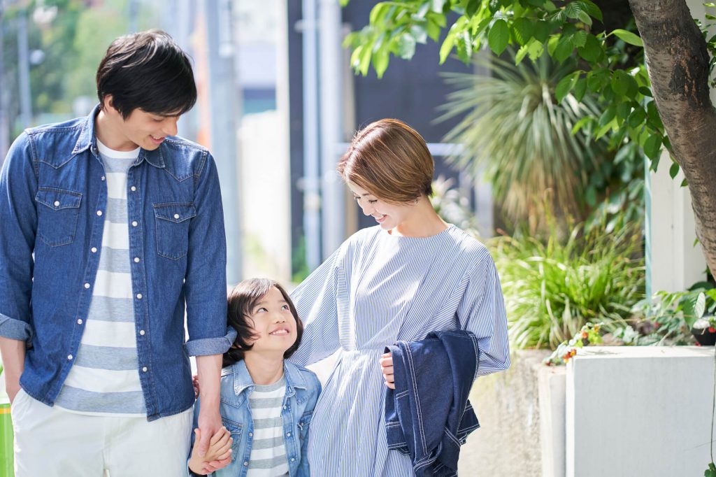 手をつないで外を歩く家族