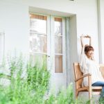 中庭の椅子に座って背伸びをする女性