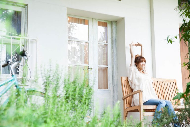 中庭の椅子に座って背伸びをする女性