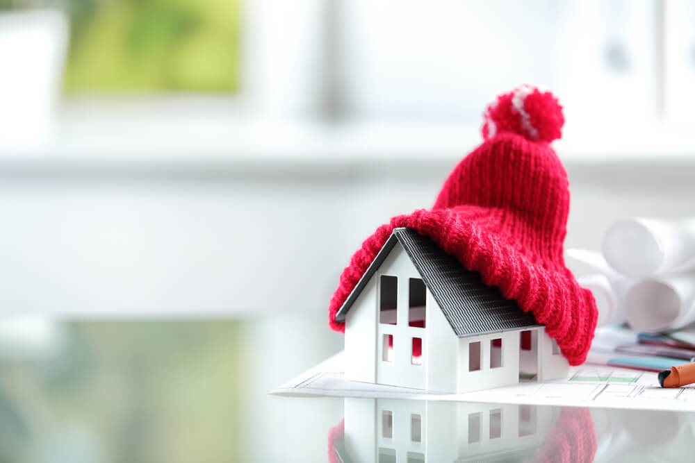 赤いニット帽を被せた家の模型